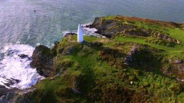 İrlanda, County Cork 'taki Baltimore Beacon' ın Hava Görüntüsü. Güzel Atlantik kıyısında gün batımı. Gün batımında deniz feneri. Günbatımında okyanusun arka planında beyaz deniz feneri. Hava görüntüleri