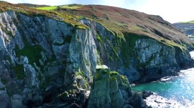 Sahildeki kayalık doğa arka planı. İrlanda, County Cork 'ta Baltimore Beacon' ın saf doğasını geziyorum. Vahşi doğanın sinematik hava manzarası dünyaca ünlü kıyı şeridi. Açık hava macerası ve seyahat