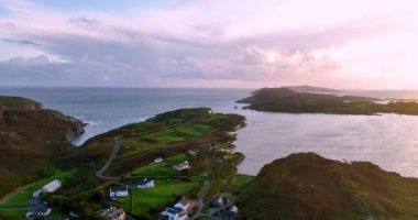 İrlanda, County Cork 'taki Baltimore Beacon' ın görüntüleri. Güzel Atlantik kıyısında gün batımı. Gün batımında deniz feneri. Günbatımında okyanusun arka planında beyaz deniz feneri. Kayalık kalır.