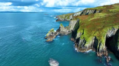 Sahildeki kayalık doğa arka planı. İrlanda, County Cork 'ta Baltimore Beacon' ın saf doğasını geziyorum. Vahşi doğanın sinematik hava manzarası dünyaca ünlü kıyı şeridi. Açık hava macerası ve seyahat