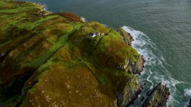 Havadan. Baltimore 'da County Cork' ta kayalık bir ada manzarasında deniz feneri olan resimli bir ev. Sherkin Adası 'ndaki deniz fenerinin üzerinden ana karadaki Baltimore Beacon' a uç.
