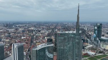 Avrupa 'da bir şehrin arka planında beyaz gökdelen. Modern bir gökdelenlerin gökdelenlerinin gökyüzünün gökyüzü manzarası. Palazzo Lombardy Bölgesi. Biblioteca degli Alberi Drone. Milan İtalya