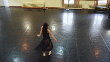 Sivri ayakkabılı profesyonel balerin ve siyah bale elbisesi çok güzel dans ediyor. Büyük salonda klasik balerin unsurlarıyla dans eden zarif balerin. Dans stüdyosu sahne ışığında bale yapıyor.