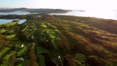 İrlanda, County Cork 'ta Baltimore Beacon. Güzel Atlantik kıyısında gün batımı. Gün batımında deniz feneri. Günbatımında okyanusun arka planında beyaz deniz feneri. Kayalık, kayaya karşı duruyor.