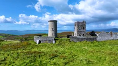 Havadan. Büyük bir adanın tepesinde antik bir deniz feneri. Atlantik Okyanusu 'nun ortasındaki yeşil bir adada antik bir deniz feneri. Yeşilin ortasındaki antik bir kalenin kalıntıları.