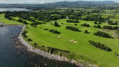 Okyanus ve Plaj yakınlarındaki Güzel Lüks Yaşam Tarzı Costal Golf Sahasının 4K Hava Dronu. Okyanusun yakınındaki kayalık bir kayalıkta resim gibi bir golf sahası. Gold Coast Golf Kulübü. Waterford Köyü