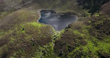 Tonelagee Dağı 'ndan Lough Ouler' in hava görüntüsü. Yeşil tepelerin ortasındaki dağ gölü. Dağın tepesindeki dağ gölünün temiz suları. Coumshingaun döngüsü. Yüksek kalite 4k