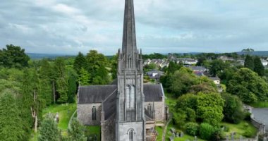Hava 4k. Dairesel. Yeşil ağaçların arkasındaki güzel kilise. St. Carthages Katedrali Lismore, Waterford, İrlanda 'nın ortasında büyük bir katolik kilisesi. Lismore Kalesi ve