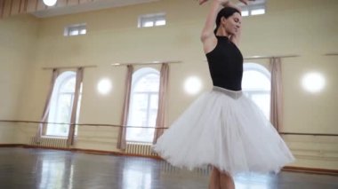 Sivri pabuçlu baş balerin ve beyaz bale eteği, piruet yapar. Dans stüdyosundaki genç klasik dansçı kadın. Bale sınıfı eğitimi. Bale okulu konsepti. Dans salonunda dönen bir balerin