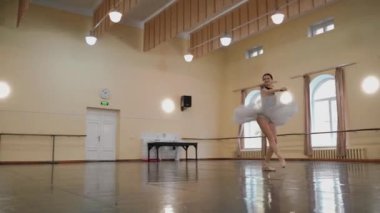 Sivri pabuçlu güzel balerin ve beyaz bale eteği ile piruet yapılır. Dans stüdyosundaki genç klasik dansçı kadın. Bale sınıfı eğitimi. Bale okulu konsepti. Tek bir yerde dönüyor. A