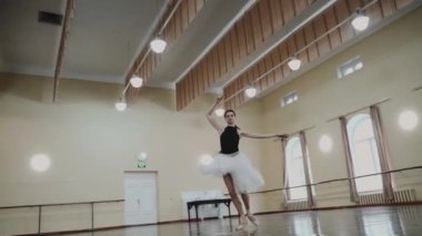 Sivri pabuçlu güzel balerin ve beyaz bale eteği ile piruet yapılır. Dans stüdyosundaki genç klasik dansçı kadın. Bale sınıfı eğitimi. Bale okulu konsepti. Bir balerin dans ederken döner.