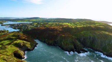 Sahildeki kayalık doğa arka planı. İrlanda, County Cork 'ta Baltimore Beacon' ın saf doğasını geziyorum. Vahşi doğanın sinematik hava manzarası dünyaca ünlü kıyı şeridi. Açık hava macerası ve seyahat