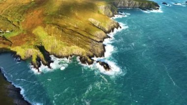 Sahildeki kayalık doğa arka planı. İrlanda, County Cork 'ta Baltimore Beacon' ın saf doğasını geziyorum. Vahşi doğanın sinematik hava manzarası dünyaca ünlü kıyı şeridi. Açık hava macerası ve seyahat