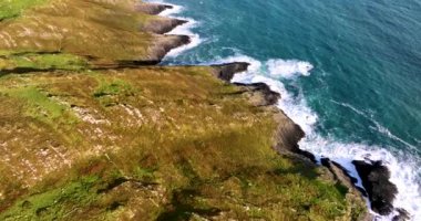 Sahildeki kayalık doğa arka planı. İrlanda, County Cork 'ta Baltimore Beacon' ın saf doğasını geziyorum. Vahşi doğanın sinematik hava manzarası dünyaca ünlü kıyı şeridi. Açık hava macerası ve seyahat