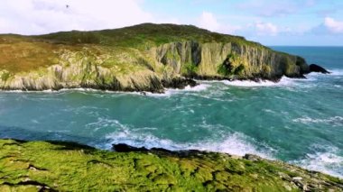 Sahildeki kayalık doğa arka planı. İrlanda, County Cork 'ta Baltimore Beacon' ın saf doğasını geziyorum. Vahşi doğanın sinematik hava manzarası dünyaca ünlü kıyı şeridi. Açık hava macerası ve seyahat