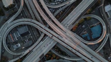 Burada çarpıcı bir hava görüntüsü var. Kalabalık bir kentsel alanda, karmaşık bir otoyol kavşağını gösteriyor. Los Angeles City 'nin iş merkezi, Golden Sunrise, ABD. Tepetaklak araba antenleri