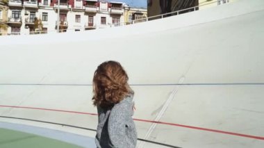 Genç bir kadın, canlı bir şehir manzarasında özgürlüğünü ve tarzını somutlaştıran açık hava ortamında dönüyor. Modern şehir yaşam tarzı ve mutluluk kavramı. Ağır çekim. Yüksek kaliteli HD görüntüler