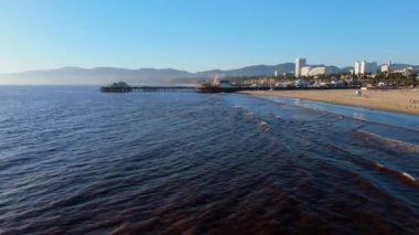 Santa Monika, LOS ANGELES, CALIFORNIA, ABD 10 EKİM, 2024: Santa Monica iskelesindeki Pacific Park 'ın insansız hava aracı görüntüsü. Turistler lunaparkta dönme dolap ve hız treniyle eğleniyorlar, 4K