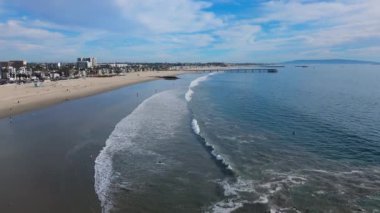Havadan. Nefes kesici deniz manzarası uzun kumlu bir sahil, ahşap iskele ve nazik dalgalar. Venice Balık İskelesi. Venice plajı, Los Angeles, ABD. 2024. Yüksek kalite 4k görüntü