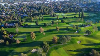Havadan. Havadan bakıldığında bir golf sahasının huzurlu güzelliğini tecrübe edin. Bu video, bereketli bir manzaranın içinde boş zamanların ve sükunetin görüntüsünü yansıtan pitoresk bir kurs gösteriyor. Los Angeles, Kaliforniya
