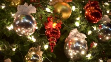 Bu, güzel dekore edilmiş Noel ağacı süsleri ve her yerde parıldayan ışıkların sergilendiği yakın çekim bir manzara. Sıcak Noel atmosferi. Yüksek kalite 4k görüntü