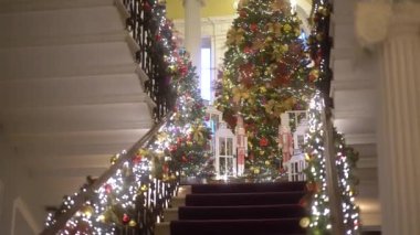 Işıklar ve oyuncaklarla süslenmiş Noel ağacı. Noel ve Yeni Yıl iç dekorasyonu. Oyuncaklarla süslenmiş yeşil ağaç, hediyeler, hediye kutuları, yanıp sönen çelenkler, yanan lambalar. Samimi Noel