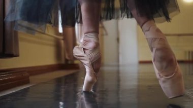 Yerde dans eden sivri uçlu ayakkabılı bir balerinin bacakları. Büyük salonda prova yaparken balerin ayakları. Sıkı çalışma ve dans eğitimi ve klasik koreografi sanatı. Yavaş Hareket