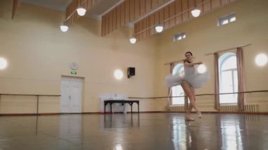 Sivri pabuçlu güzel balerin ve beyaz bale eteği ile piruet yapılır. Dans stüdyosundaki genç klasik dansçı kadın. Bale sınıfı eğitimi. Bale okulu konsepti. Tek bir yerde dönüyor. A