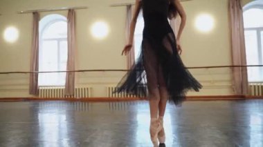 Balerin, koridorda bir bacağının üzerinde, parlak pencerelerin önünde dönüyor. Güzel dans figürleri gösteriyor. Baş balerin büyük bir salonda klasik balerin unsurlarıyla dans eder. Antrenman odası