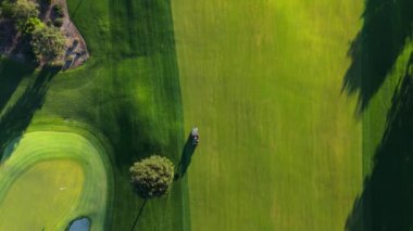 Bu video, güzel bir golf sahasının manzaralı bir görüntüsünü içeriyor. Burada bireyler golf oynamaktan zevk alıyor, boş zamanları ve rekabeti vurguluyor. Lakeside Golf Kulübü. Universal City, Los Angeles, ABD