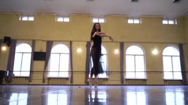 Dans stüdyosunda klasik bale öğeleri dans eden zarif balerin. Yetenekli beyaz kız stüdyoda bale figürleri yapıyor. Profesyonel koreograf olmak için dansçı eğitimi. Sanatlar