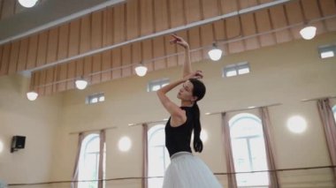 Dans stüdyosundaki profesyonel bayan balerin portresi. Bale sınıfı eğitimi. Bale okulu konsepti. Büyük pencereli bir dans salonunda dönen bir balerin. Ağır çekim. Yüksek kalite