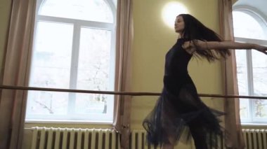 Baş balerin bale salonunun ortasında dairesel hareketler yapıyor. Zarif dans eden kız balesi. Güzel dans figürleri gösteriyor. Zarif balerin klasik balerin unsurlarıyla dans eder.