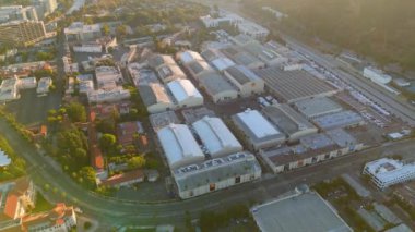 Hava görüntüleri şehir mimarisi ve yeşillik karışımı canlı bir şehir manzarası yakalar. İnsansız hava aracı görüntüleri çeşitli binaları ve sakin bir nehri vurguluyor, doğa ve kentsel gelişimi gözler önüne seriyor