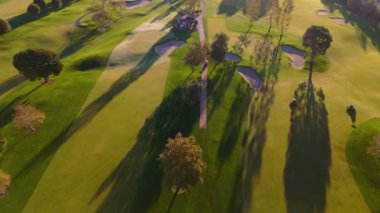 Bu havadaki golf sahasının dingin güzelliğini keşfedin, renkli otlaklar, uzun ağaçlar ve hareketli topluluğun tadını çıkaran oyuncular. Lakeside Golf Kulübü. Universal City, Los Angeles, ABD