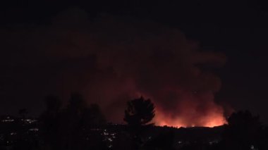 10 Ocak 2025 'te Palisades, Kaliforniya yakınlarındaki tepelerde çıkan büyük bir yangının gece görüntüsü. Bu dramatik sahne, Sherman 'daki bir alışveriş merkezinin bakış açısından çekildi.
