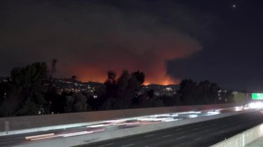 Sherman Oaks 'tan yakalanan bu dramatik gece görüntülerinde Pasifik Palisades, Kaliforniya' da bir yangının ön planda karayolu trafiği ile yandığı görülüyor. 10 Ocak 2025 'te çekilmiş.