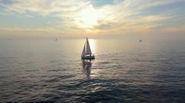 Sakin sularda süzülen bir kayıkla çarpıcı bir günbatımına karşı sakin bir yelken sahnesi, ihtişamlı doğalar sergiliyor. Sakin sularda gün batımı macerasının nefes kesici güzelliğini tecrübe et.