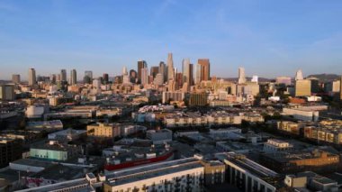 Los Angeles, Kaliforniya şehir merkezinin 4k hava görüntüsü, 2 Ocak 2025 'te çekildi. Canlı şehir manzarası modern gökdelenleri ve şehrin sıcacık gündoğumu altında yayılışını sergiliyor. Yüksek kalite 4K.