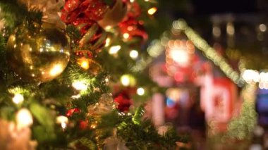Canlı bir Noel sahnesi, güzel ışıklar, renkli süsler ve neşeli bir neşe ile canlanır. Oyuncaklarla süslenmiş yeşil ağaç, hediyeler, hediye kutuları, yanıp sönen çelenkler, yanan lambalar. Samimi