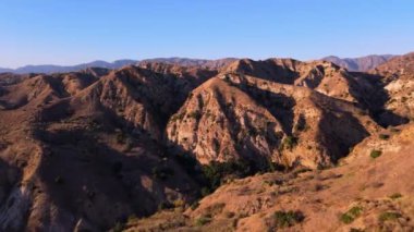 Şubat 2025 'te Kaliforniya' nın engebeli dağlarını gösteren hava görüntüleri. Derin kanyonları ve yuvarlanan tepeleri olan kuru, kayalık arazi bölgenin doğal güzelliğini vurguluyor.