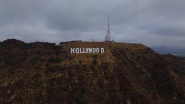 Los Angeles, Kaliforniya 'daki ikonik Hollywood tabelasının 24 Ekim 2024' te çekilmiş sinematik bir yakın çekimi. İnsansız hava aracı ünlü şehir simgesine sorunsuzca yaklaşıyor.