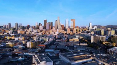 Los Angeles, California şehir merkezinin sinematik hava manzarası, gün doğumunda altın sabah ışığı ile yıkanmış. 2 Ocak 2025 'te yakalanan bu görüntüler canlı şehir siluetini ve ikonik