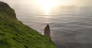 Havadan. Turistler Moher 'in uçurumundaki puslu yolu takip ediyorlar. Anne ve çocuk, Moher Kayalıkları 'ndaki uçurumlar boyunca turist yolunda bir uçurum boyunca yürüyorlar. Güzel gün batımı. Country Clare.