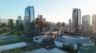Gece gökyüzünü aydınlatan parlak renklerle şehir merkezindeki gökyüzünün büyüleyici gündoğumu manzarasının tadını çıkarın. Bu hava manzarası, Los Angeles 'ın modern mimarisi ve...