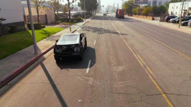 Kaliforniya 'da bir şehir caddesi boyunca sürerken görülen hasarlı bir Tesla Cybertruck' ın editör görüntüleri. Yavaş çekim, araçların fütüristik dizaynını yakalar ve sonrasını ön plana çıkarır.