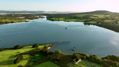 Sakin bir göl ve bereketli bir kırsal bölgenin havadan görünüşü, sakin doğa ve keşif için manzaralı güzellikler sergiliyor. Gölün ortasında batık bir tekne. Gemi battı, gemi karaya oturdu. A