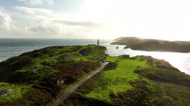 İrlanda, County Cork 'taki Baltimore Beacon' ın Hava Görüntüsü. Güzel Atlantik kıyısında gün batımı. Gün batımında deniz feneri. Günbatımında okyanusun arka planında beyaz deniz feneri. Kayalık yer