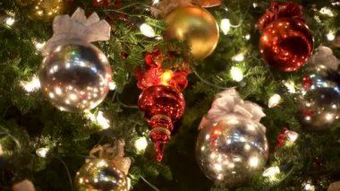 Bu, güzel dekore edilmiş Noel ağacı süsleri ve her yerde parıldayan ışıkların sergilendiği yakın çekim bir manzara. Sıcak Noel atmosferi. Yüksek kalite 4k görüntü