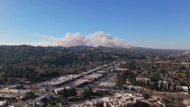 Pasifik Palisades, Los Angeles 'taki bir yangını gösteren İHA görüntüleri. Yoğun duman gökyüzüne yükseliyor, önlerinde kentsel bir alan olan tepelere yayılıyor. 11 Ocak 'ta yakalanan bu video...